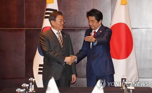 문재인 대통령과 아베 신조 일본 총리가 24일(현지시간) 중국 쓰촨성 청두 세기성 샹그릴라호텔에서 정상회담에 앞서 악수하고 있다.   청두=연합뉴스